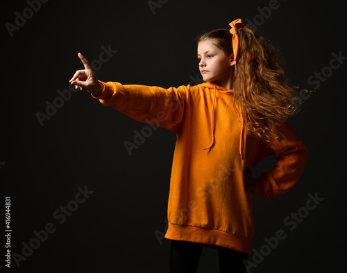 Fotografia Candid and determined teen girl showing stop sign standing on black background