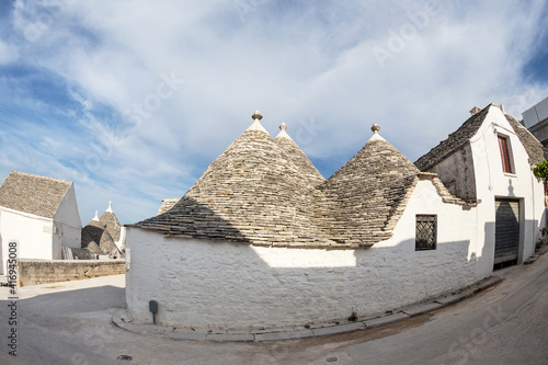 Typical street in Alberobello  a Trulei village  with white houses with a tapered stone roof. Photo taken with a fisheye lens.