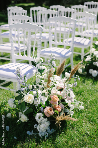 White chairs lined up for wedding ceremony. flower composition, decoration