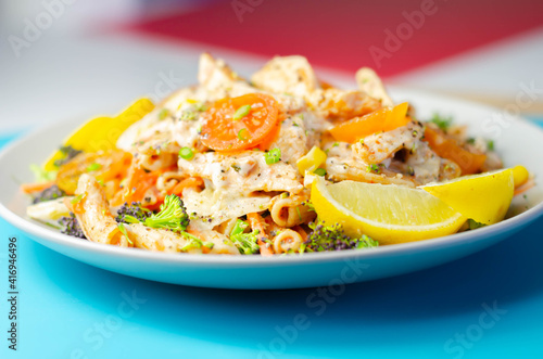 Piri piri style chicken on a bed of wholewheat pasta and vegetables, with a cool sour cream and chive dressing