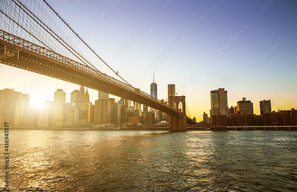 View of Brooklyn Bridge and Manhattan skyline WTC Freedom Tower from Dumbo at sunset, Brooklyn. Brooklyn Bridge is one of the oldest suspension bridges in the USA