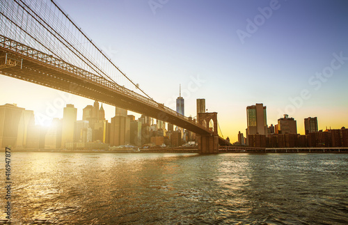 View of Brooklyn Bridge and Manhattan skyline WTC Freedom Tower from Dumbo at sunset, Brooklyn. Brooklyn Bridge is one of the oldest suspension bridges in the USA