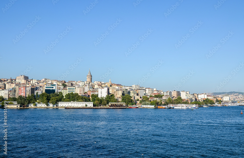 Scenic view with one of the symbolism of old Istanbul, Galata Tower at skyline from the seaside, landscape of Golden Horn, Turkey