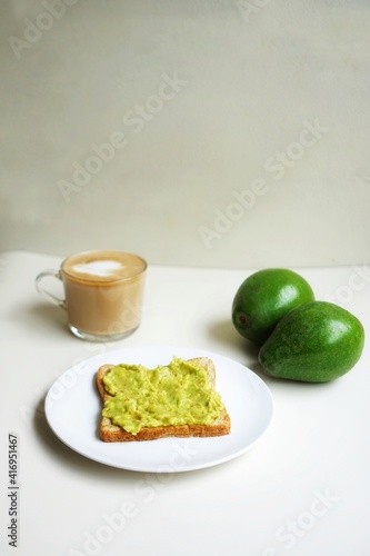 Avocado toast, americano coffe, and latte on a white table 