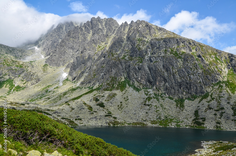 Beautiful mountain lake  Batizovske Pleso, surrounding peaks and the highest peak of High Tatras mountains, Gerlachovsky stit. Slovakia