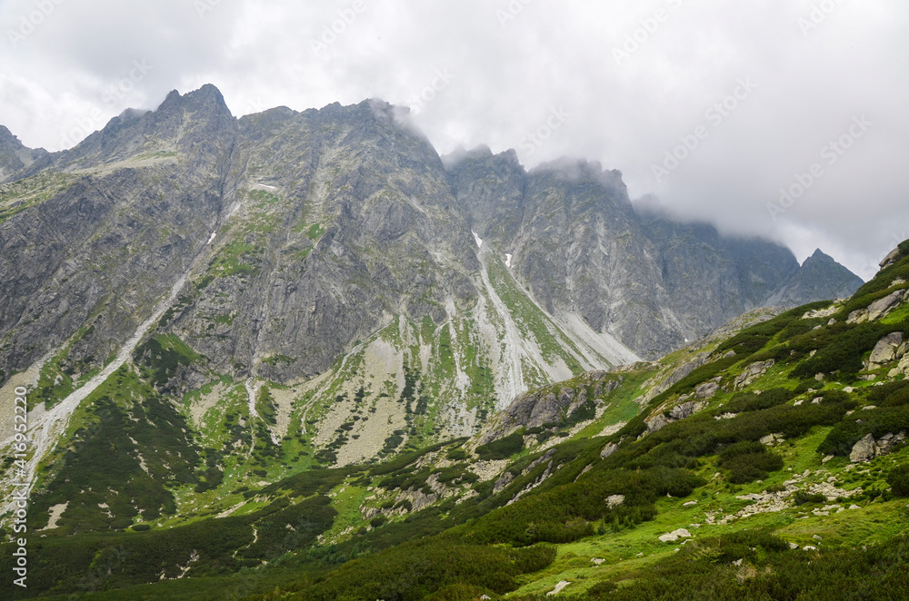Obraz premium Mountain landscape. High mountains in the low clouds. Nature of High Tatras mountains. Slovakia, Europe.