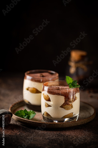 Tableau sur toile Traditional Italian dessert tiramisu in a glass on on dark background