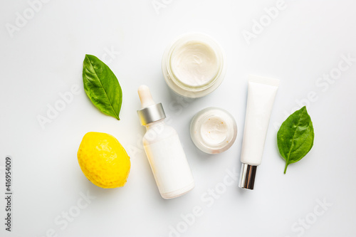Flat lay composition with skin care products and lemon fruit on white background