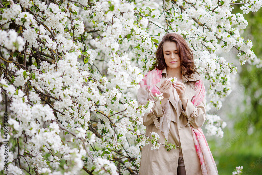 Portrait of a beautiful smiling brunette young women in blossom apple tree garden in spring time. Enjoy Nature. Healthy girl outdoor. Spring concept. Beautiful girl in orchard Portrait of a beautiful smiling brunette young women in blossom apple tree garden in spring time. Enjoy Nature. Healthy girl outdoor. Spring concept. Beautiful girl in orchard