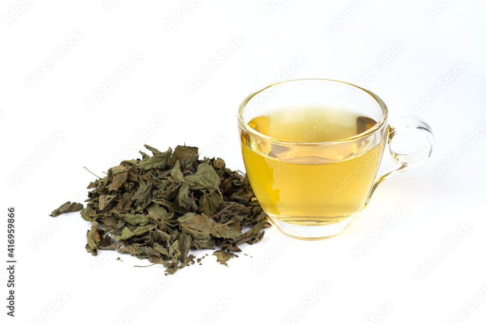Tulsi or holy basil tea in transparent cup with pile of dried tulsi leaf isolated on white background. Ayurvedic medicine in India. Drink for health. Tulsi or holy basil tea in transparent cup with pile of dried tulsi leaf isolated on white background. Ayurvedic medicine in India. Drink for health.