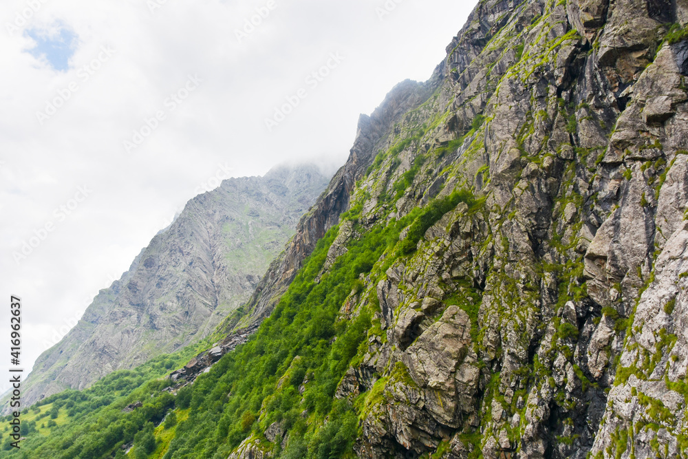 Beautiful mountain peaks of the North Caucasus against the backdrop of a blue cloudy sky. Republic of North Ossetia - Alania Beautiful mountain peaks of the North Caucasus against the backdrop of a blue cloudy sky. Republic of North Ossetia - Alania