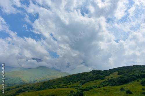 Beautiful mountain peaks of the North Caucasus against the backdrop of a blue cloudy sky. Republic of North Ossetia - Alania