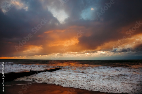 Storm waves near the shore on the beach. In the foreground, breakwaters. © MadCat13Shoombrat