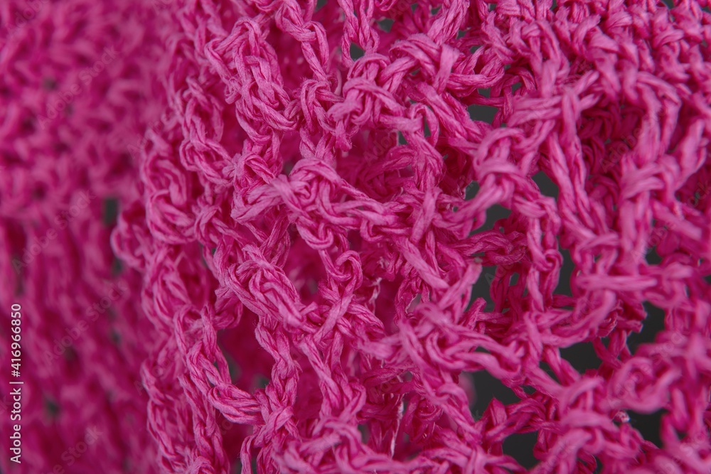 Close up of pink raffia wickerwork on grey background