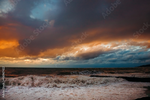 Abstract and colorful storm clouds. Sea sunset. A storm at sea. The waves hit the shore. © MadCat13Shoombrat