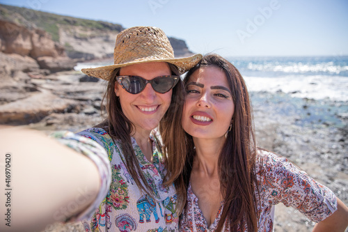 Two happy girls on vacation take a selfie at the beach. © Media Lens King