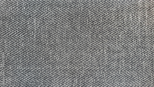 black herringbone tweed fabric pattern background with closeup on laminated material .wool fabric texture. 