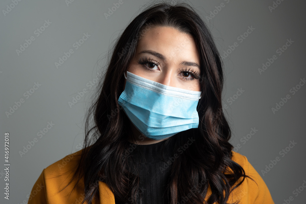 Beautiful young Latina business woman wearing a protective mask. Beautiful young Latina business woman wearing a protective mask.