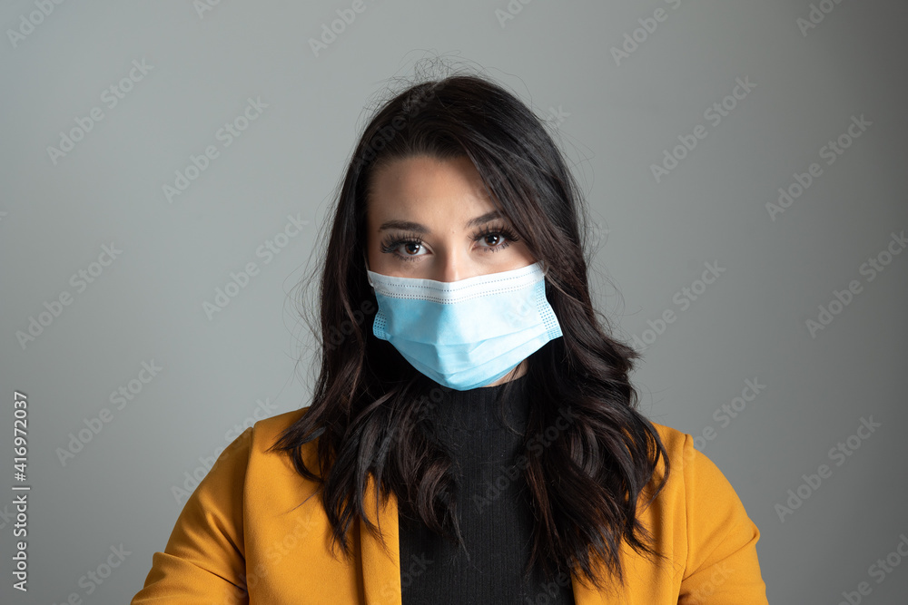 Beautiful young Latina business woman wearing a protective mask. Beautiful young Latina business woman wearing a protective mask.