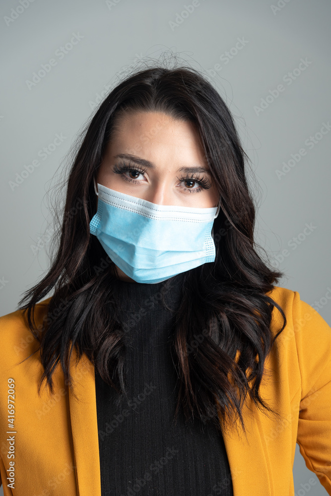 Beautiful young Latina business woman wearing a protective mask. Beautiful young Latina business woman wearing a protective mask.