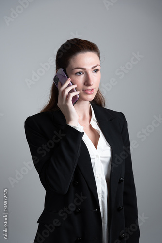 Pretty young business woman using mobile phone. 