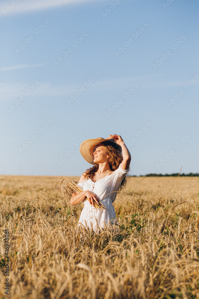 Girl with long curly hair poses in a wheat field Girl with long curly hair poses in a wheat field