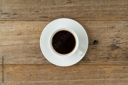 A cup of coffee on a shabby wooden board background. Flat lay.