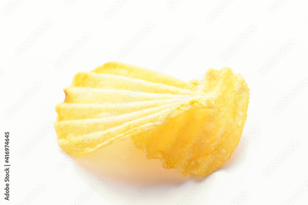 Yellow corrugated salted two potato chips on a white background, close up