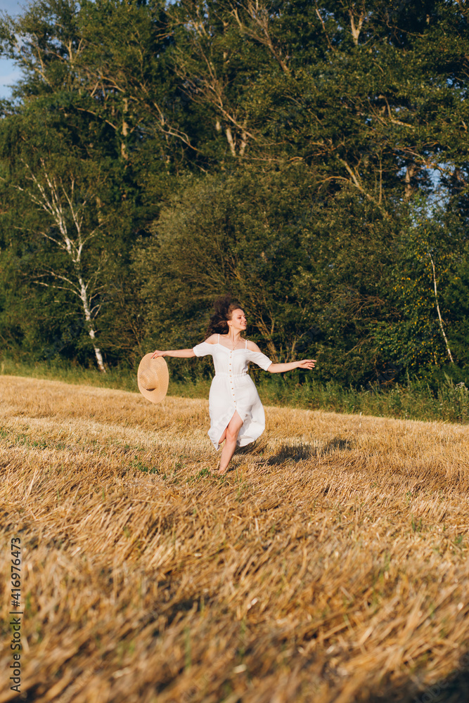 Girl with long curly hair poses in a wheat field Girl with long curly hair poses in a wheat field