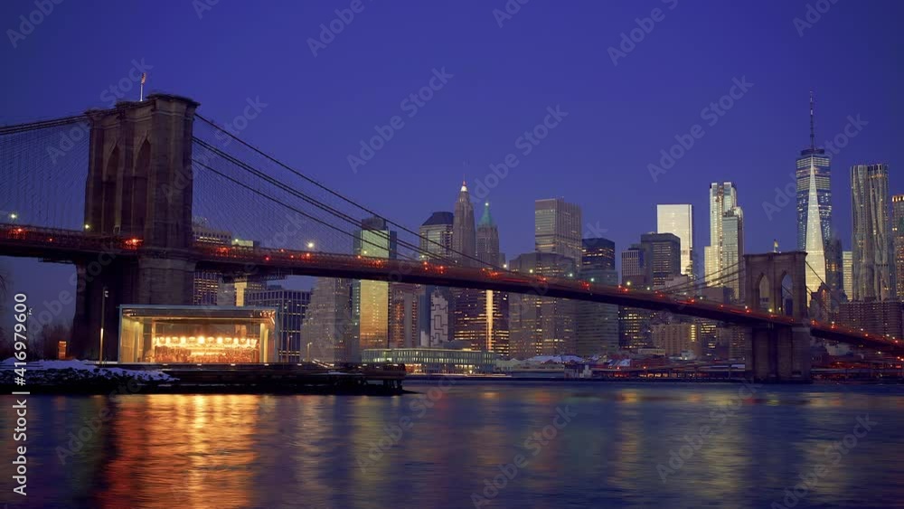 Panoramic view of Brooklyn bridge and Manhattan at sunrise, New York City. Time lapse of night to day transition. Panoramic view of Brooklyn bridge and Manhattan at sunrise, New York City. Time lapse of night to day transition.