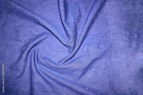 Top view of circular spiral fabric, blue denim fabric, blue cloth background, spiral swirl fabric, swirl cloth, Twisted background, twisted cloth.