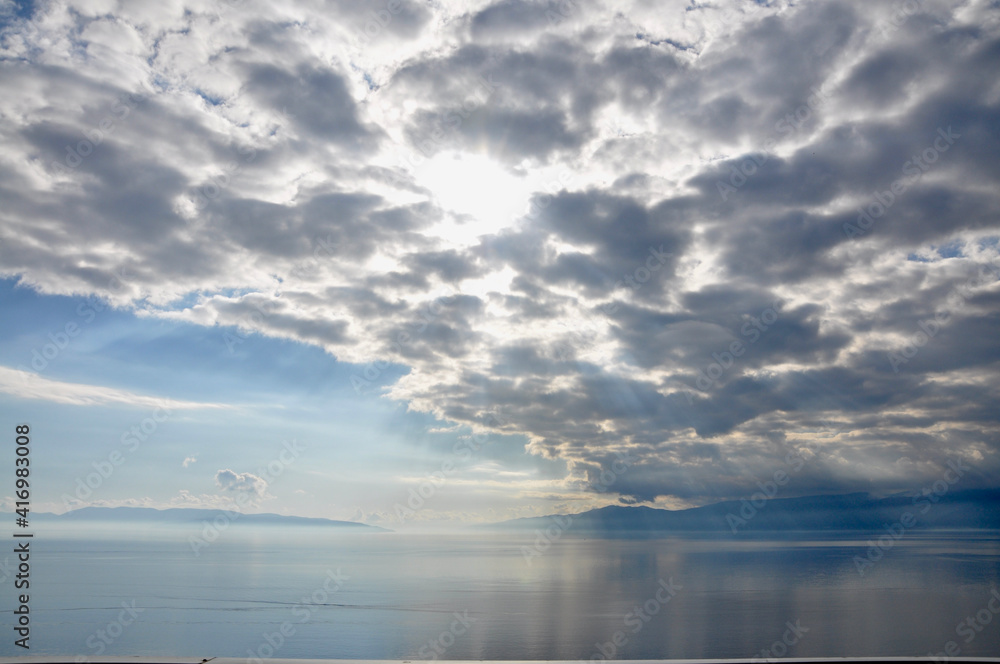 Cloudscape with sunrays over sea in Rijeka, Croatia. Sea on cloudy sky. Clouds on dramatic sky. Evening nature and sunset. Freedom and wanderlust concept.