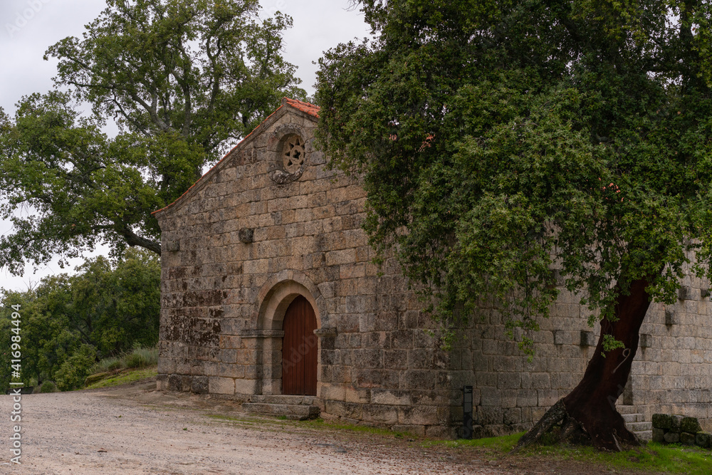 Landscape view of Sao Pedro chapel with trees and boulders in Monsanto, Portugal