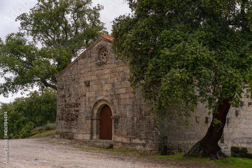 Landscape view of Sao Pedro chapel with trees and boulders in Monsanto, Portugal