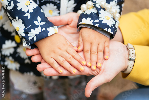 warm hands of mom. baby palms in the hands of mom. jacket in colors.