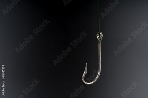 Fishing hook on a black background. trap, catch on, risk. Business concept idea photo
