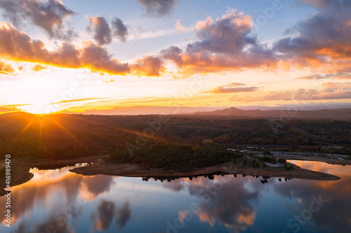 Drone aerial view of a lake reservoir of a dam with perfect reflection on the water of the sunset in Sabugal, Portugal