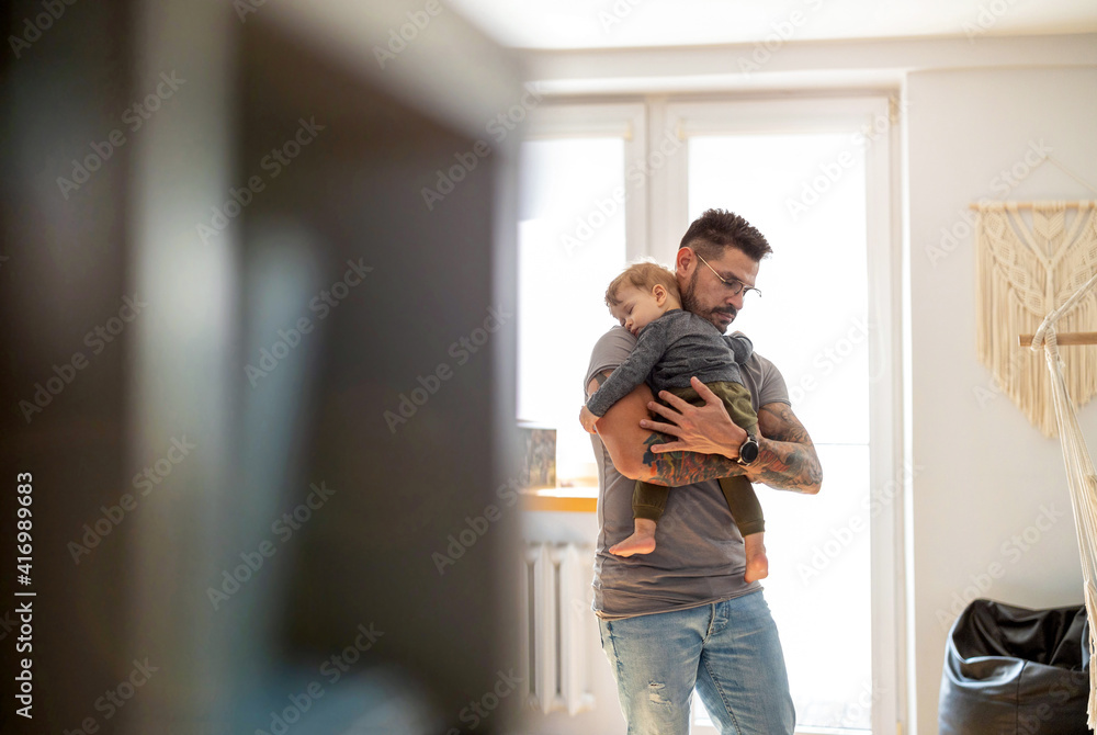 Dad putting to sleep baby boy in his arms at home
Dad putting to sleep baby boy in his arms at home