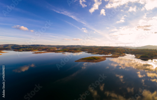Drone aerial view of a lake reservoir of a dam with perfect reflection on the water of the sky in Sabugal, Portugal © Luis
