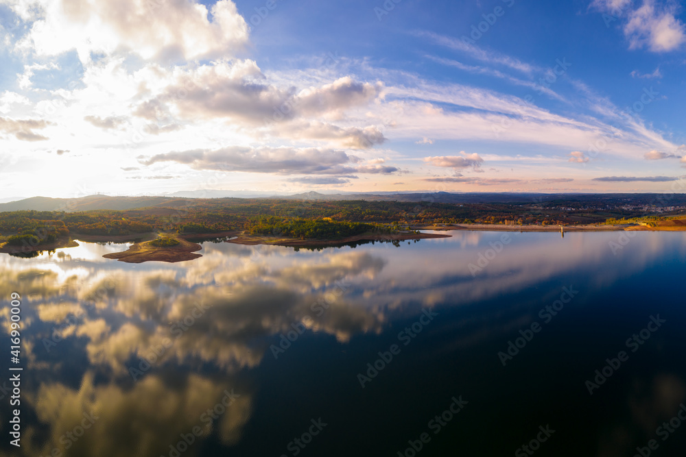 Drone aerial view of a lake reservoir of a dam with perfect reflection on the water of the sky in Sabugal, Portugal Drone aerial view of a lake reservoir of a dam with perfect reflection on the water of the sky in Sabugal, Portugal