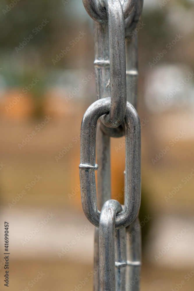 Strong shiny silver chain, outdoors, park background Strong shiny silver chain, outdoors, park background