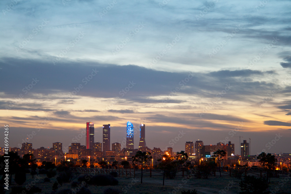 Madrid skyline at sunset, highlighting the four towers of the financial district to the north of the city