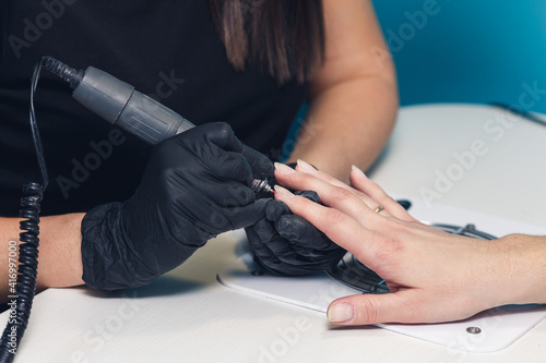 nail polishing procedure. Professional hardware manicure on an electric machine in a beauty salon.