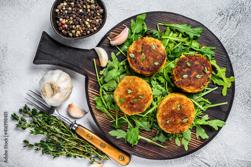 Veggie patty cutlet with lentils, vegetables and arugula. White background. Top view