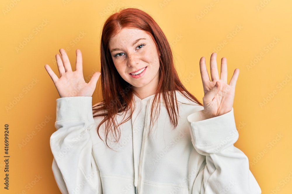 Young red head girl wearing casual sweatshirt showing and pointing up with fingers number nine while smiling confident and happy. Young red head girl wearing casual sweatshirt showing and pointing up with fingers number nine while smiling confident and happy.