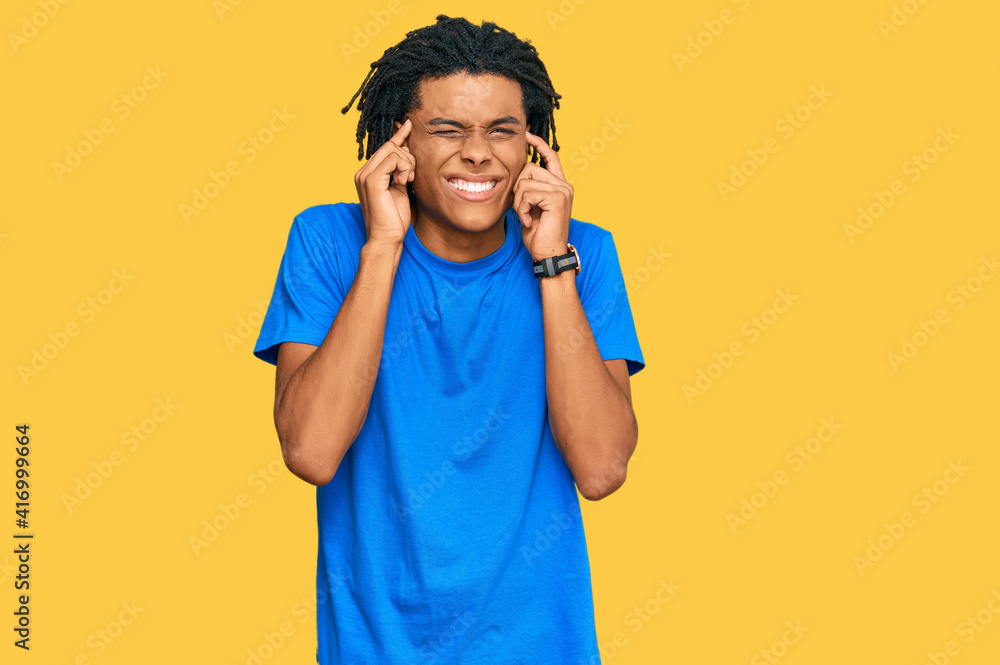 Young african american man wearing casual clothes covering ears with fingers with annoyed expression for the noise of loud music. deaf concept. Young african american man wearing casual clothes covering ears with fingers with annoyed expression for the noise of loud music. deaf concept.