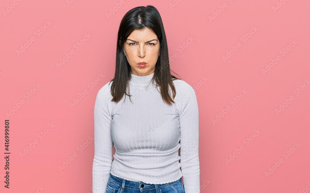 Beautiful brunette woman wearing casual clothes puffing cheeks with funny face. mouth inflated with air, crazy expression. Beautiful brunette woman wearing casual clothes puffing cheeks with funny face. mouth inflated with air, crazy expression.