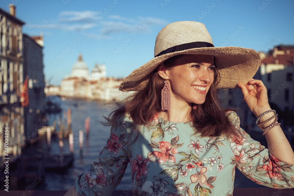 smiling elegant woman in floral dress having walking tour