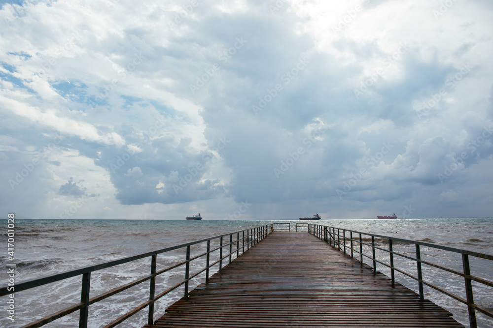 clouds over the sea. pier going into the distance clouds over the sea. pier going into the distance
