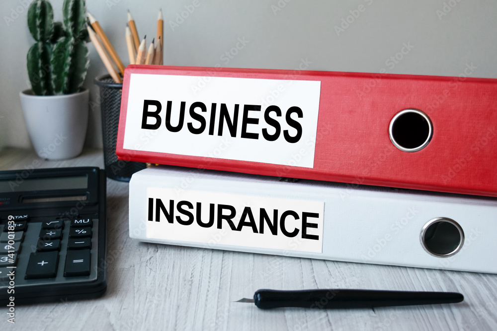 Red and white folders with documents lying on the desktop next to a calculator and a pen. The lettering on the folder has financial or marketing significance. Business concept. Red and white folders with documents lying on the desktop next to a calculator and a pen. The lettering on the folder has financial or marketing significance. Business concept.